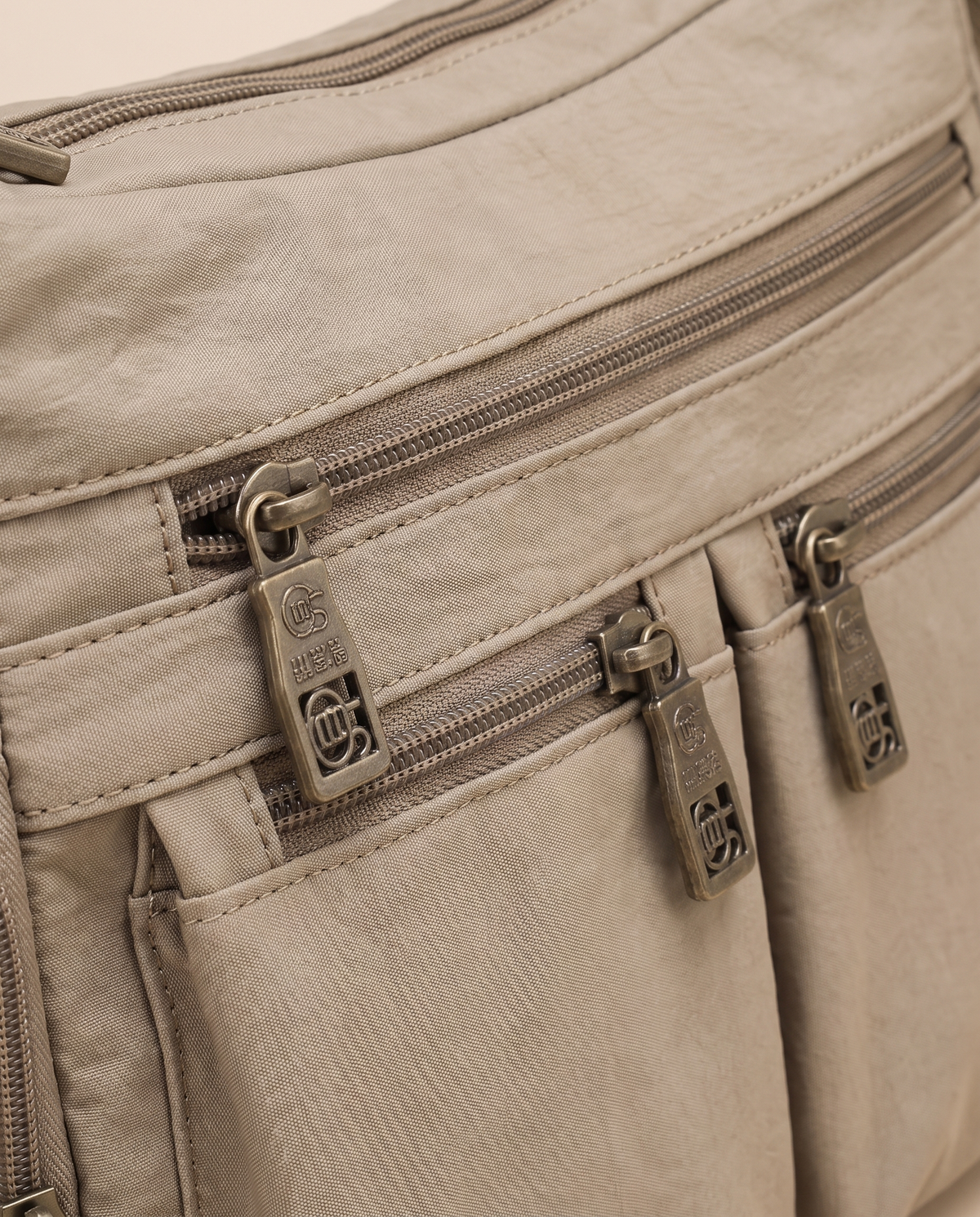Kia crossbody bag, close-up of the front zip pockets
