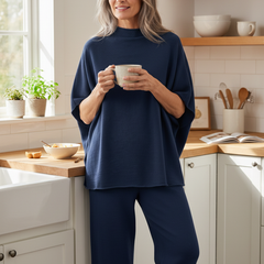 Woman in her fifties wearing the navy mock neck lounge set in a bright kitchen