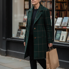 Woman walking past a bookshop in the green checked wool coat